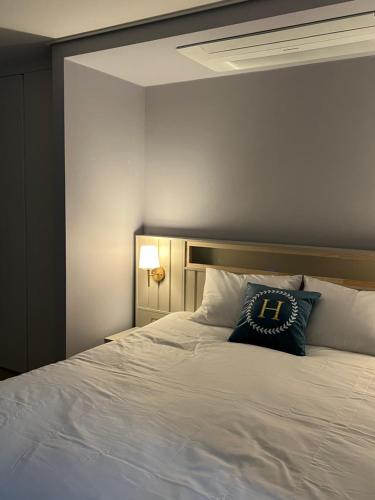 a bed with a blue pillow on top of it at Hoya stay in Yeosu