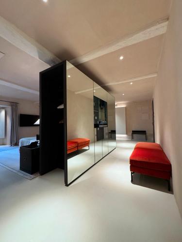 a bedroom with a red bed and a mirror at Hotel Palazzo Durazzo Suites in Genova