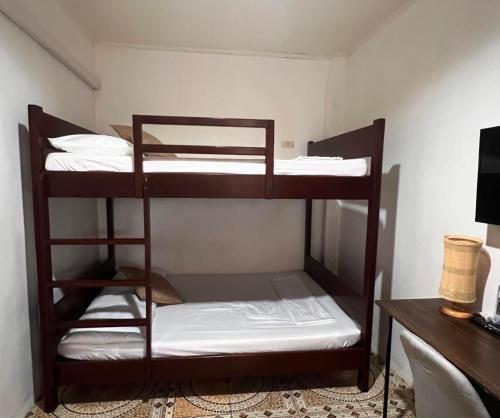 two bunk beds in a room with a desk at Sunny Terrace in Baler