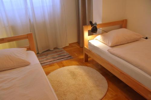 um pequeno quarto com 2 camas e um tapete em Sunshine Apartment em Bijeljina