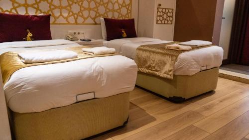 a room with three beds with towels on them at İpek Palas Otel in Urfa