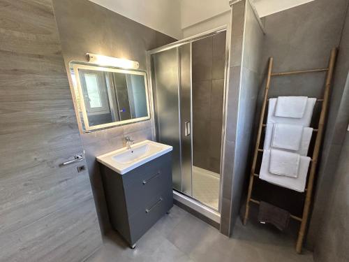 a bathroom with a sink and a shower and a mirror at Lime House Corfu in Potamós