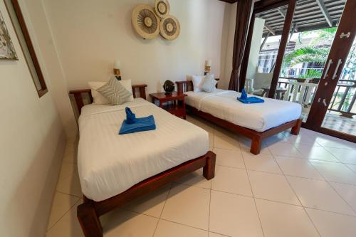 a bedroom with two beds with blue towels on them at Wind Beach Resort in Koh Tao