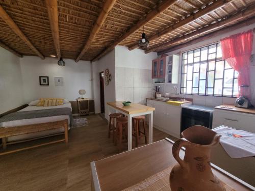 Zimmer mit einem Bett und einer Küche mit einem Tisch in der Unterkunft Casa Huerta in Chincha Alta
