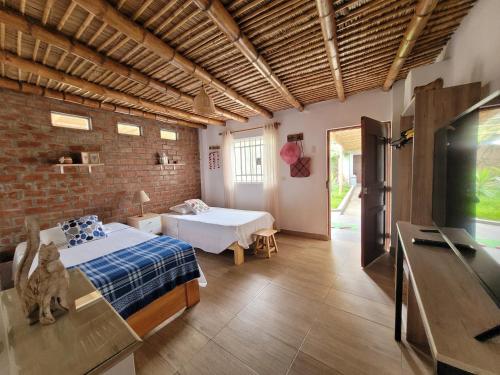 ein Schlafzimmer mit einem Bett und einer Ziegelwand in der Unterkunft Casa Huerta in Chincha Alta