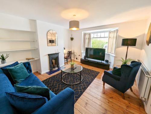 a living room with a blue couch and a tv at CENTRAL CAMBRIDGE, CHARMING 3-Bed HOUSE WITH FREE PARKING! in Cambridge