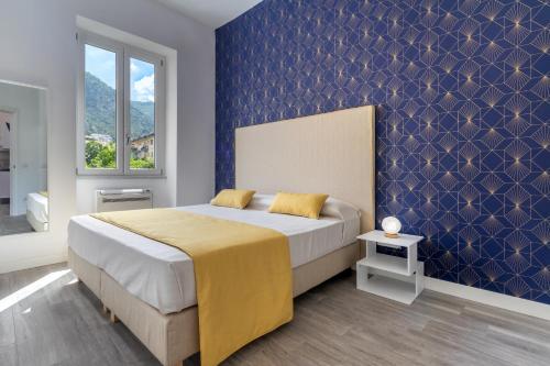 1 dormitorio con 1 cama grande y pared azul en Casa Ersilia, en Meta