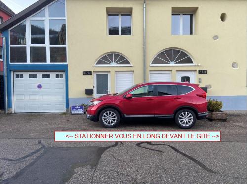 a red car parked in front of a house at Appartement à Mitzach in Mitzach