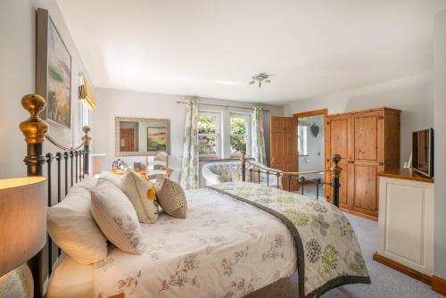 a bedroom with a large bed with a wooden headboard at Killoran House in Dervaig