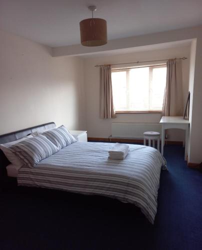 a bedroom with a bed and a window and a desk at Maple Lodge in Cheltenham