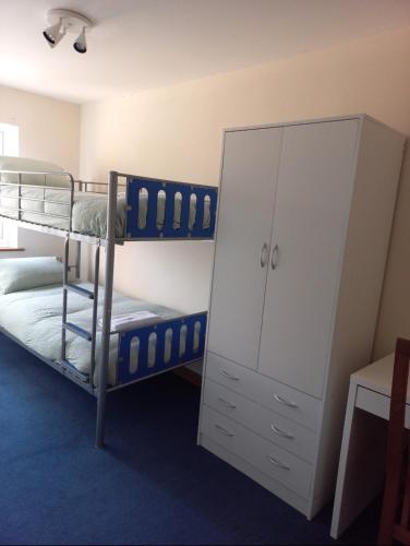 a bedroom with two bunk beds and a cabinet at Maple Lodge in Cheltenham