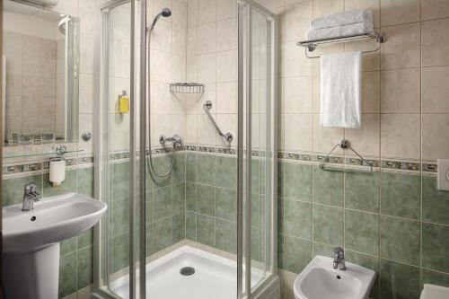 a bathroom with a shower and a sink at Alqush Downtown Hotel in Prague