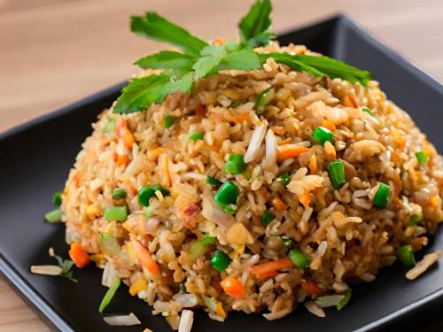 a black plate of rice with carrots and peas at Chanmel Riverside in Chanthaburi