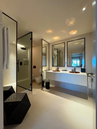 a bathroom with a tub and a sink and mirror at Hotel Palazzo Durazzo Suites in Genova