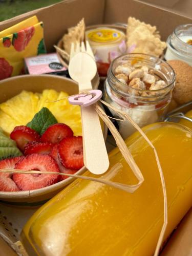 een doos vol fruit en een kom honing en een kom fruit bij Na Quinta- alojamento rural com piscina de água salgada in Poceirão