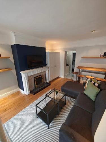 uma sala de estar com um sofá e uma lareira em Delightful 3 Bed Dublin City House em Dublin