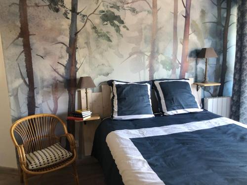 - une chambre avec un lit et une peinture d'arbres dans l'établissement Lac Christus - Studio classé 3*, à Saint-Paul-lès-Dax