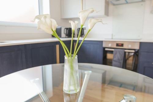 um vaso com flores brancas sentado numa mesa em Peaceful 2 Bed Townhouse, Close to City Centre em Reading