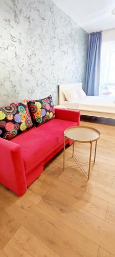a red couch in a living room with a table at STUDIO JACUZZI BELLE VIEW SINAIA-free parking in Sinaia