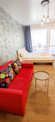 a living room with a red couch and a bed at STUDIO JACUZZI BELLE VIEW SINAIA-free parking in Sinaia