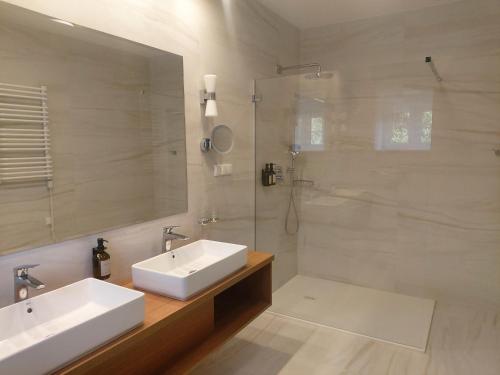 a bathroom with two sinks and a glass shower at Villa Le Lux in Mikołajki