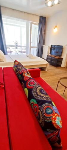 a red couch with a pillow on top of it at STUDIO JACUZZI BELLE VIEW SINAIA-free parking in Sinaia