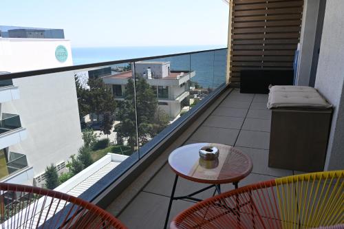 een balkon met een tafel en stoelen en de oceaan bij Astria Boutique Apartments 313 in Olimp
