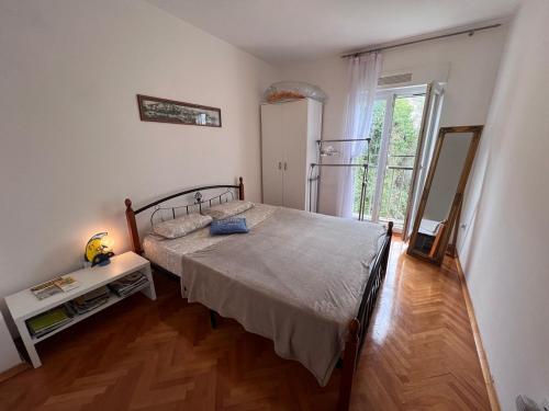 a bedroom with a bed and a large window at Apartments "Helios" in Njivice