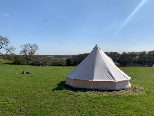 een witte tent in een grasveld bij Penn Meadow Farm in Buckinghamshire