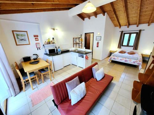 a living room with a red couch and a kitchen at Quinta Reuffurth in Aljezur