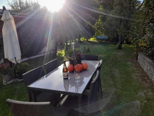 einen Tisch mit Kürbissen und Weinflaschen darauf in der Unterkunft Le Gai Pinson in Beausaint