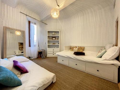 2 Betten in einem Schlafzimmer mit weißen Wänden in der Unterkunft Magnifique appartement vue mer et parking privé ! in Grasse