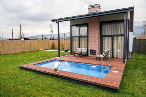 un patio trasero con piscina y una casa en Vital Göl Sapanca Isıtmalı Havuzlu Bungalov & Villa, en Sapanca