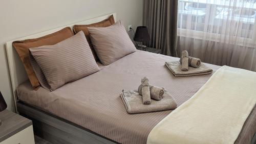 sypialnia z łóżkiem z dwoma ręcznikami zwierzęcymi w obiekcie Lux 2 Central Apartment with Garage w Płowdiwie