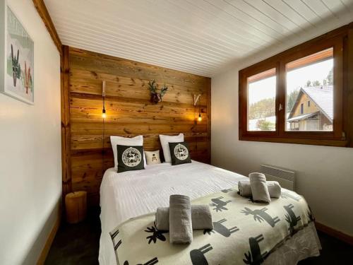 une chambre avec un lit dans une pièce aux murs en bois dans l'établissement Chalet du Pré - Sauna, terrasse et grand jardin, à Xonrupt-Longemer
