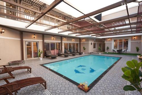 a large swimming pool in a building with a patio at EKOSTAY Luxe - Highland Villa in Panchgani