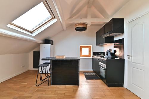 une cuisine avec des armoires noires et un comptoir noir dans l'établissement Cocoon d'Ébène - À 20 min du parc Disneyland Paris, à Tournan-en-Brie