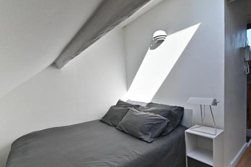 a bed in a white room with a window at Cocoon d'Ébène - À 20 min du parc Disneyland Paris in Tournan-en-Brie