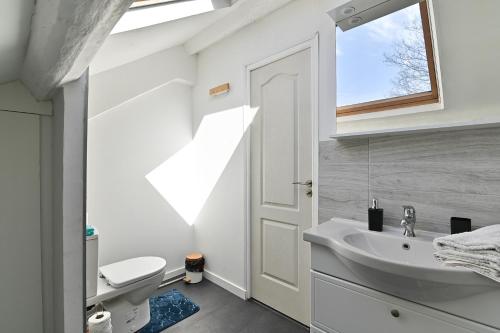 a bathroom with a sink and a toilet and a window at Cocoon d'Ébène - À 20 min du parc Disneyland Paris in Tournan-en-Brie