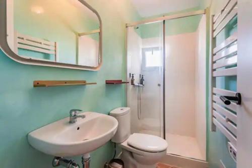 a bathroom with a sink and a toilet and a mirror at Suite 3 in Mahón