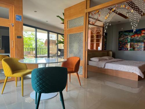 a bedroom with a bed and a table and chairs at Pattaya Condo Wongamat Privacy Resort - Naklua in North Pattaya
