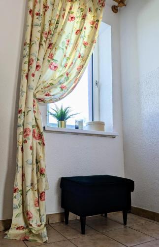 a window with a curtain and a bench in a room at SB Apartment with Sauna in Kołobrzeg