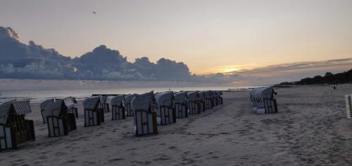 a row of beach chairs on a sandy beach at SB Apartment with Sauna in Kołobrzeg