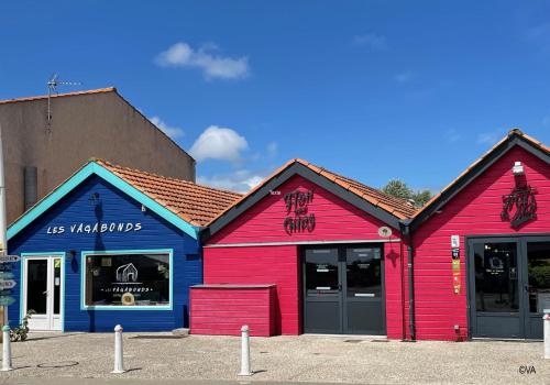 a red and blue building in a parking lot at Large and comfortable mobile home Clp17 2Ch Siblu Les Charmettes in Les Mathes