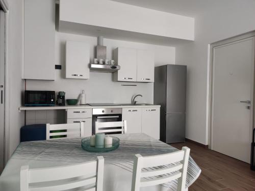 a kitchen with a table and chairs and a kitchen with white cabinets at VerdeLago Como Lake in Malgrate