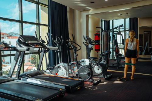 Eine Frau steht in einem Fitnessraum mit Kardiogeräten. in der Unterkunft Sarrosa International Hotel and Residential Suites in Cebu City