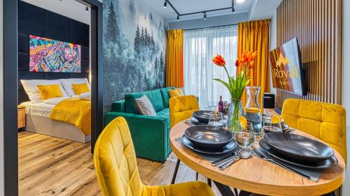 une salle à manger avec une table et des chaises jaunes dans l'établissement OSTOJA RESIDENCE VIP ze strefą relaksu i pokojem zabaw by Royal Aparts, à Szklarska Poręba
