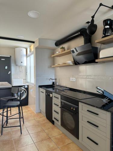 uma cozinha com um fogão e uma máquina de lavar louça em Vistas al Mar, Piscina y Playa em Alicante