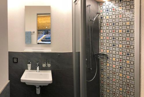 een badkamer met een wastafel en een douche bij BnB Fellacher in Adelboden