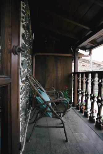 a bench sitting on the porch of a house at La Casita de Coelho in Doade